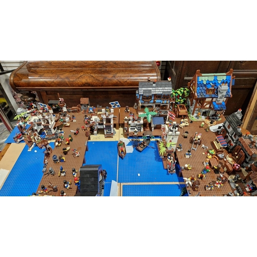 755 - A large Lego Pirate Town diorama featuring several Lego sets to include No.4194 4194 Whitecap Bay, N... 