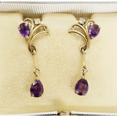 329 - Pair of 9ct gold stud earrings, each set with a teardrop amethyst and diamond within the scrolling s... 