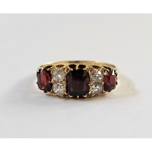 500 - 18ct gold, garnet and diamond ring, the three graduated mix cut garnets interspersed by two pairs of... 