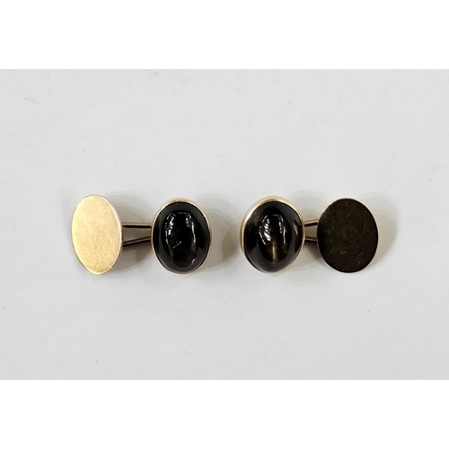 505 - Pair of gold-coloured cufflinks, each set with an oval brown stone cabochon displaying Chatoyancy