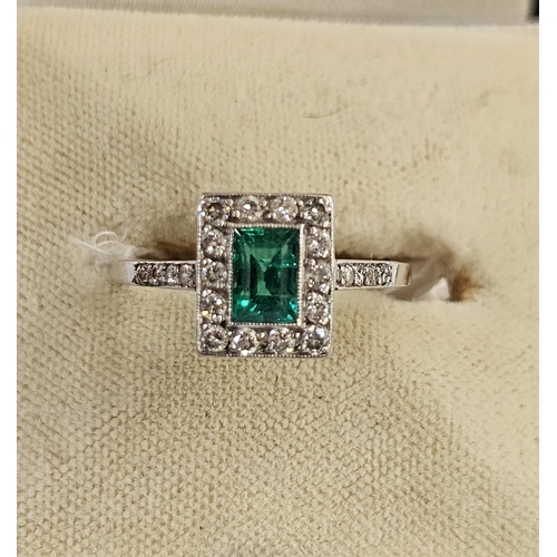 510 - White metal, diamond and emerald ring, the central cut emerald within a border of 14 brilliant cut d... 