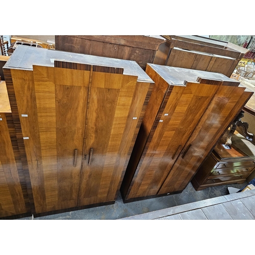 1042 - Pair of Art Deco walnut veneer and rosewood effect wardrobes with stepped pediments, the two panel d... 