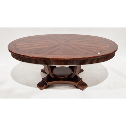 1128 - Modern mahogany veneered coffee table, the oval quarter-veneered top with carved fluted frieze, on f... 