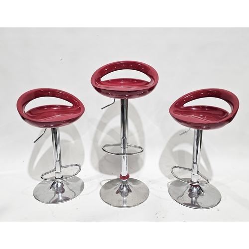 1201 - Three retro style modern red and chrome adjustable bar stools, each with footrest and circular bases... 