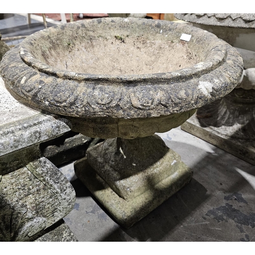 1238 - Pair of composite stone garden terrace urns of campana form, with moulded egg and dart rim, on a squ... 