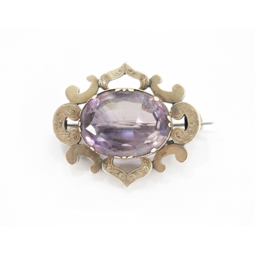 186 - Victorian gold-coloured metal and purple stone brooch, the oval amethyst-coloured stone within C-scr... 