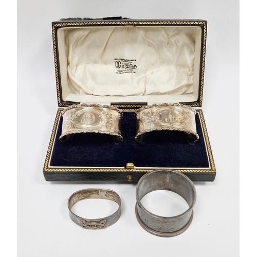 230 - Pair of George V silver cased napkin rings, Chester 1922, J & R Griffin, of oval form with cast scro... 