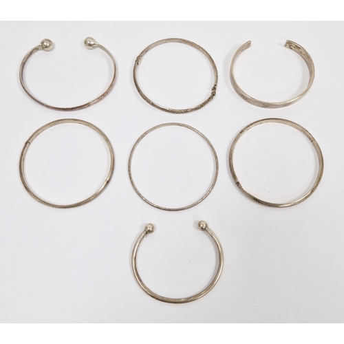 275 - Three silver torque bangles, silver hinged bracelet with engraved decoration and three further silve... 