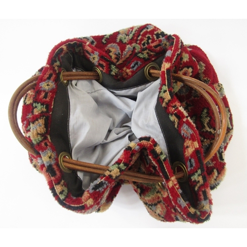 13 - Carpet bag labelled Carpet Bags Suffolk England, with leather strap handles, patterned on a dark red... 