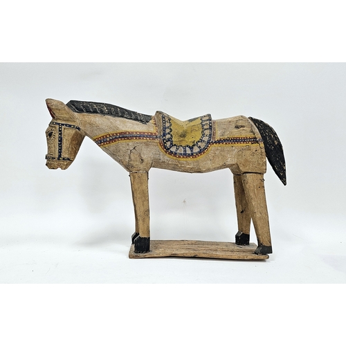 145 - Folk Art hand carved and painted model of a horse or donkey, wearing a saddle, on a plank base, 46cm... 