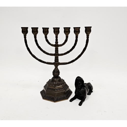 165 - Patinated brass model of an Egyptian sphinx, 12.5cm long and a brass menorah candle holder on a hexa... 