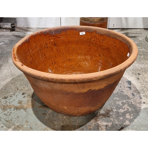 162 - Large 19th century terracotta dairy bowl with a glazed interior surface, 34cm high x 63cm diameter