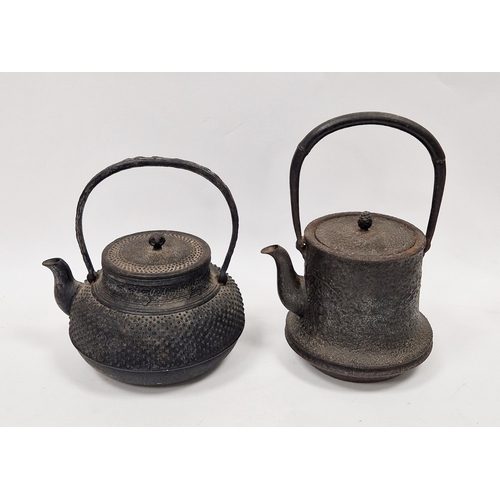 120 - Two Japanese cast iron teapots and covers (Tetsubin), the first cast with dimples, with swing handle... 