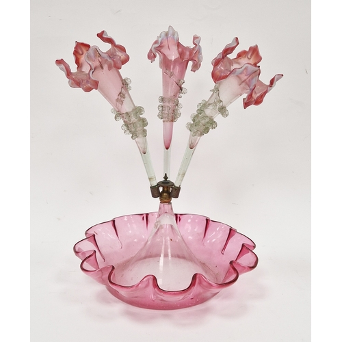 99 - Victorian cranberry glass three-trumpet epergne, with applied rigaree to trumpets, all raised on a d... 