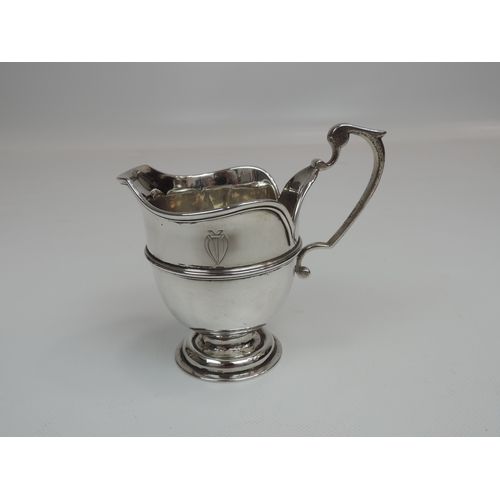 14 - A Late Victorian Silver Milk/Cream Jug with a Central Girdle, Raised Petal Rim, C-scroll Handle and ... 