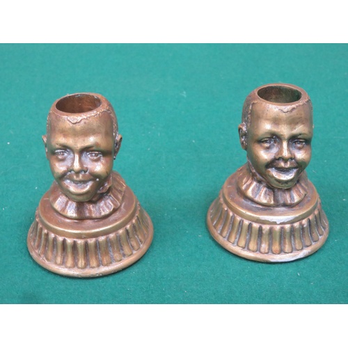 265 - Pair of character cast iron masks (Bottles Openers) and a pair of cast brass candle sticks