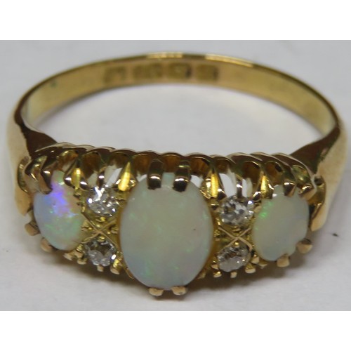 275 - 18ct gold dress ring, set with three opal coloured stones and four small clear stones. Total weight ... 