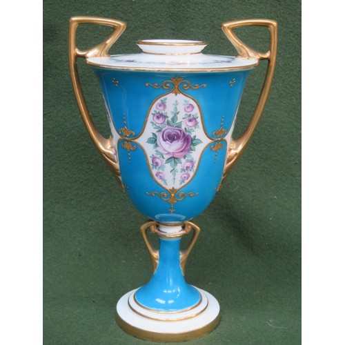 102 - Mintons decorative gilded two handled urn, decorated with floral panels. Approx. 26cms High