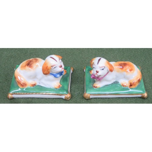 104 - Pair of small late 19th/ early 20th century ceramic figures, depicting recumbent dogs on cushions, s... 