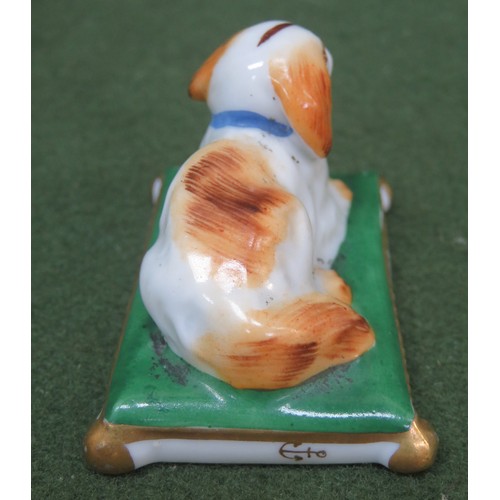 104 - Pair of small late 19th/ early 20th century ceramic figures, depicting recumbent dogs on cushions, s... 