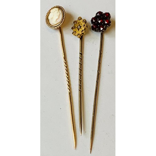 21 - ONE UNMARKED YELLOW METAL PIN WITH A CAMEO, ONE UNMARKED YELLOW METAL PIN SET WITH SEVEN GARNETS, ON... 