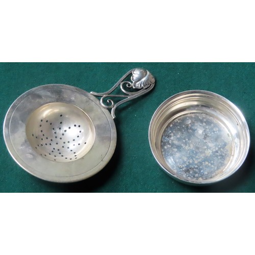 293 - Pretty Danish silver tea strainer with floral piercework decorated handle, with matching dish, by Jo... 