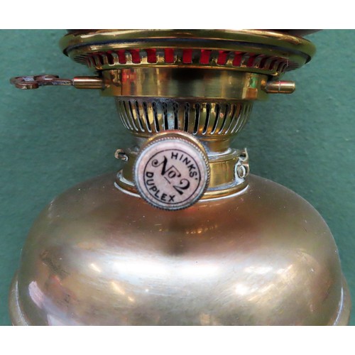 239 - Hinks Duplex decorative brass stemmed oil lamp with ruby coloured shade. Approx. 54cm H