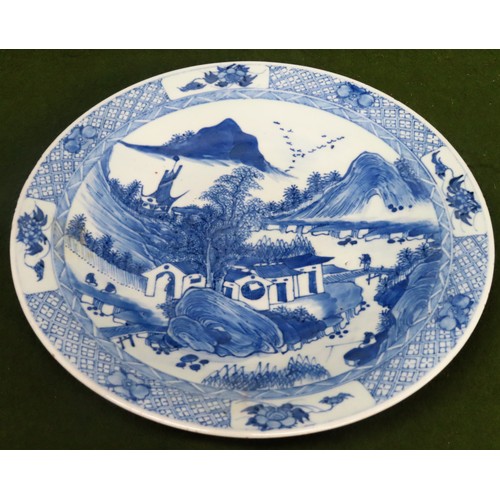 225 - Oriental blue and white glazed ceramic plaque depicting a village scene. Approx. 31cms D