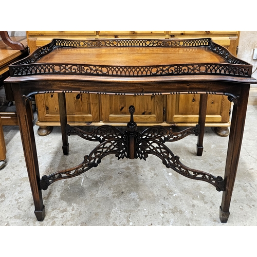 27 - 20th century heavily piercework decorated mahogany shaped topped serving table. Approx. 72 x 87 x 47... 