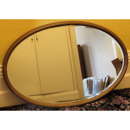 86 - Large 19th/20th century gilded and bevelled oval wall mirror. Approx. 63 x 95cm