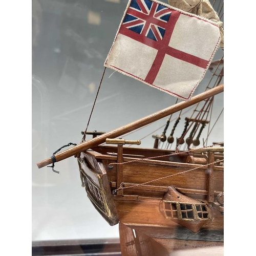 101 - A wooden model of HMS Bounty, with deck fittings, on a stand, in a perspex display case, overall dim... 