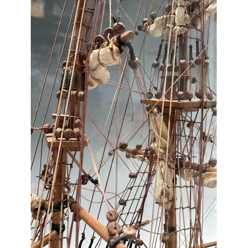 101 - A wooden model of HMS Bounty, with deck fittings, on a stand, in a perspex display case, overall dim... 