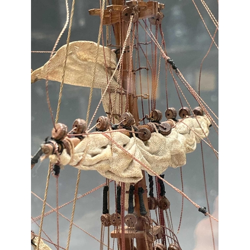 101 - A wooden model of HMS Bounty, with deck fittings, on a stand, in a perspex display case, overall dim... 