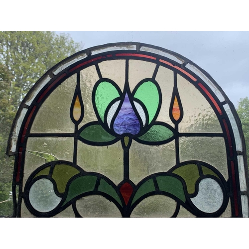 141 - An early 20th century leaded and stained glass panel of arched form. Height 45cm, width 59cm.