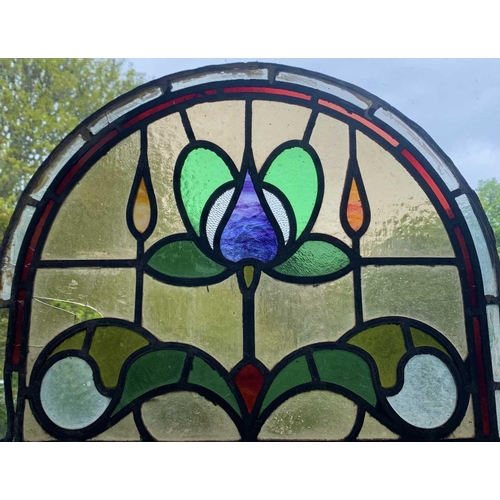 141 - An early 20th century leaded and stained glass panel of arched form. Height 45cm, width 59cm.