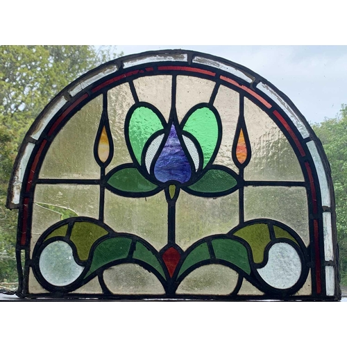 141 - An early 20th century leaded and stained glass panel of arched form. Height 45cm, width 59cm.