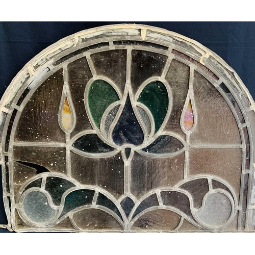 141 - An early 20th century leaded and stained glass panel of arched form. Height 45cm, width 59cm.