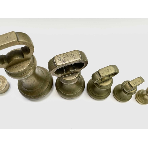 144 - A group of nine brass bell weights, 7LB to 1/2OZ, the biggest height 18.5cm, together with a nest of... 