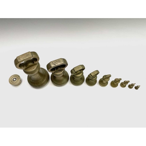 144 - A group of nine brass bell weights, 7LB to 1/2OZ, the biggest height 18.5cm, together with a nest of... 