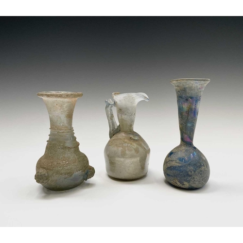 15 - Three iridescent glass vessels, possibly Roman, comprising a ewer, height 13cm, and two vases. Prove... 