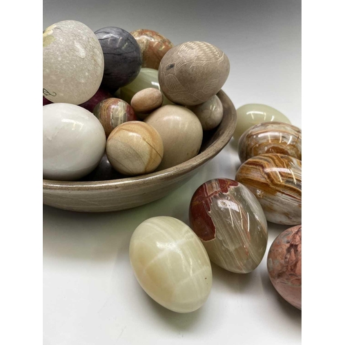 179 - A large collection of carved hardstone eggs. Heights 7cm diminishing.