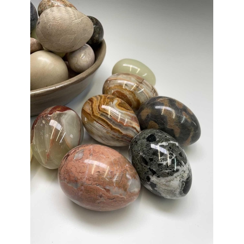 179 - A large collection of carved hardstone eggs. Heights 7cm diminishing.