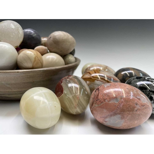 179 - A large collection of carved hardstone eggs. Heights 7cm diminishing.