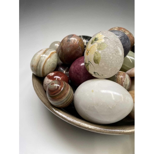 179 - A large collection of carved hardstone eggs. Heights 7cm diminishing.