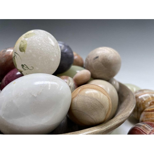 179 - A large collection of carved hardstone eggs. Heights 7cm diminishing.