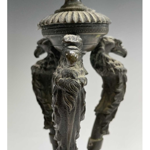 207 - A Regency bronze candlestick, the nozzle supported by three eagle headed monopodia, on a triform bas... 