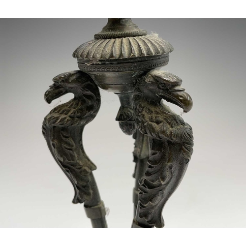 207 - A Regency bronze candlestick, the nozzle supported by three eagle headed monopodia, on a triform bas... 