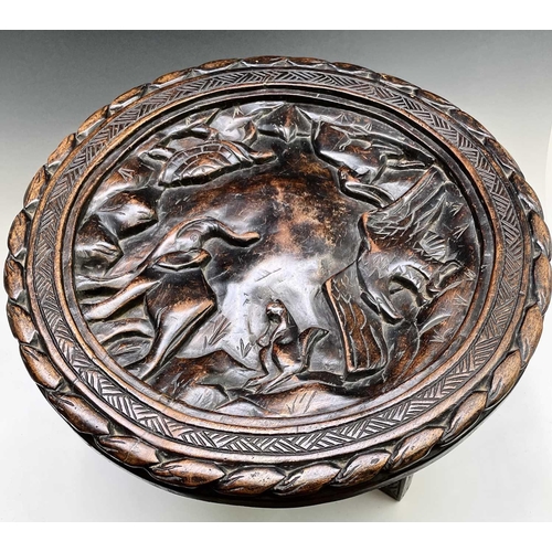 208 - An African circular hardwood occasional table, the top carved with an elephant, eagle, antelope, tor... 