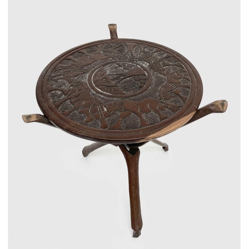 209 - An African carved hardwood table, raised on a folding tripod base, diameter 44cm.