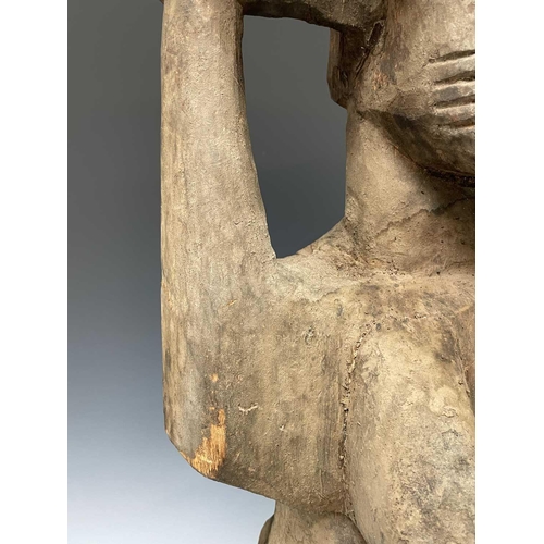 245 - A large African carved wood statue of a female figure holding a bowl above her head. Height 89cm